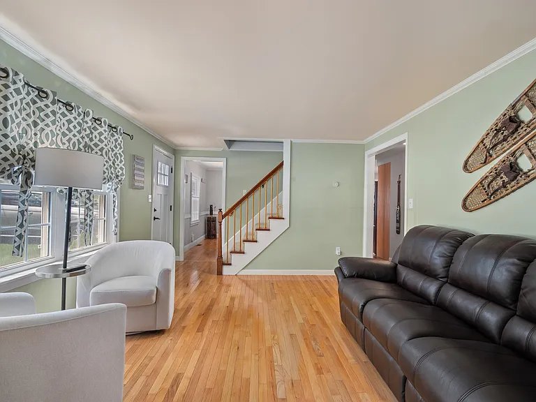 The second living room at night — quiet corner with snowshoe wall decor at The Brookhurst Lake House